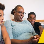 Grandmother reading a book to grandchildren.